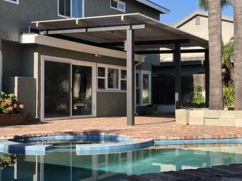Traditional-style Solara adjustable louvered cover in Adobe, motorized, on espresso 4K posts and support beam
